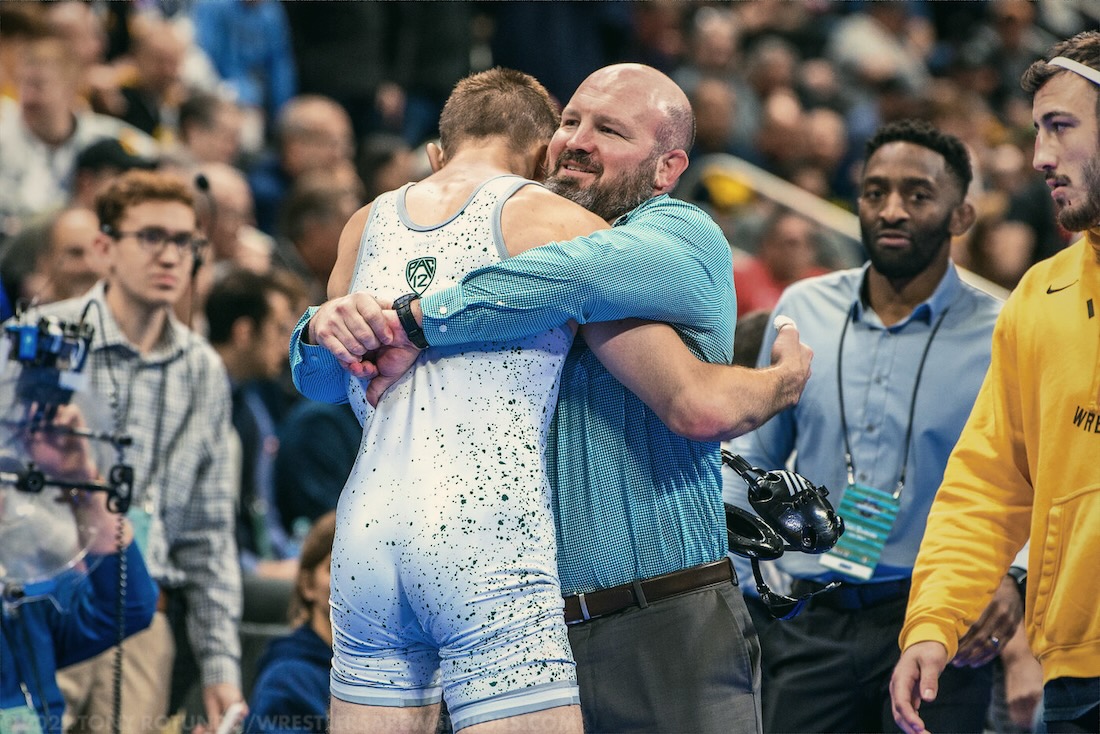 Jon Sioredas embracing a Cal Poly wrestler at the NCAA Championships